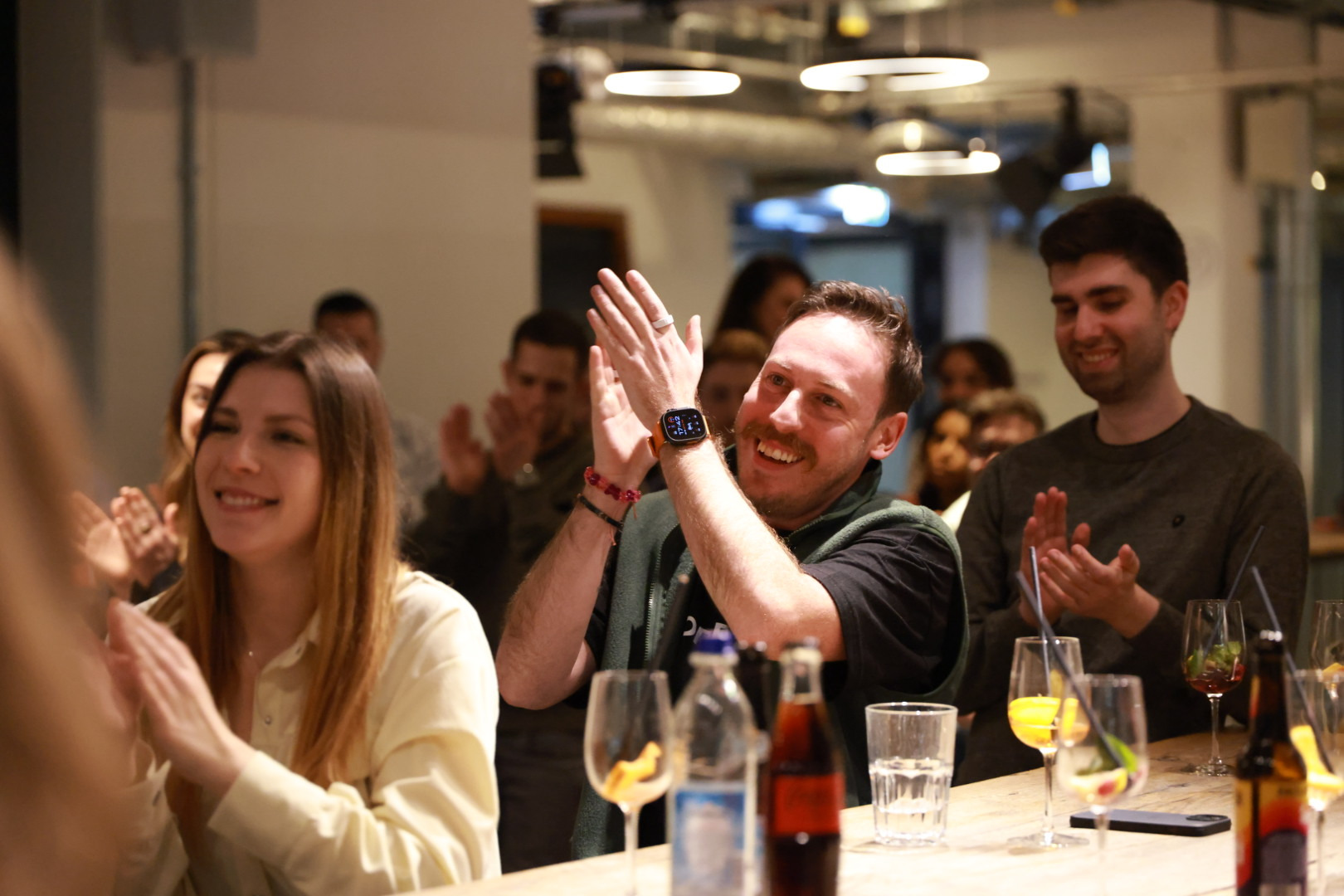 Client team members applauding and smiling at the end of a session at an AI Operator client kick-off in Munich.