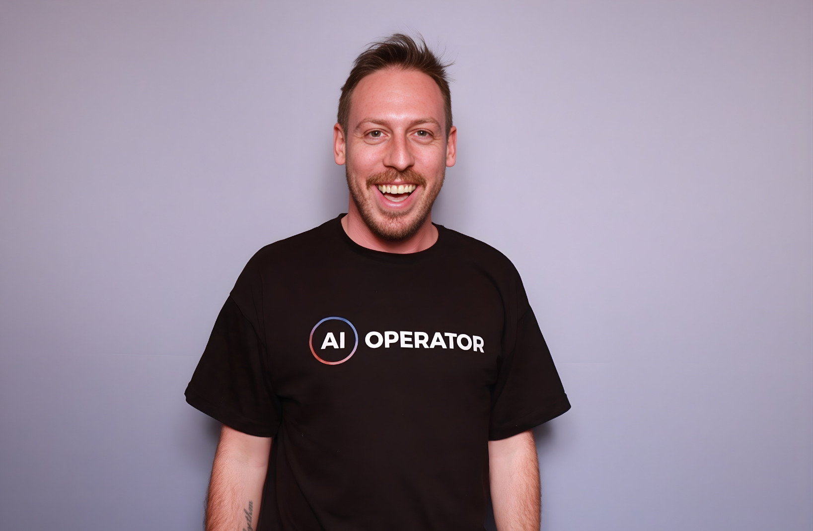 Studio portrait of Tim Cakir in an AI Operator t-shirt, laughing.